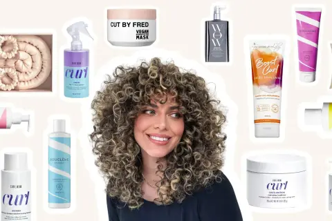 Une femme aux cheveux bouclés naturels rayonne, entourée de produits pour le soin des cheveux bouclés.