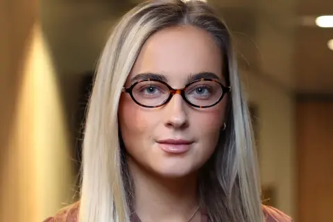 Evelina Andersson med glasögon och blont hår.