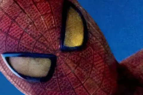 Zbliżenie na charakterystyczne, żółte oczy Spidermana na czerwonym tle.