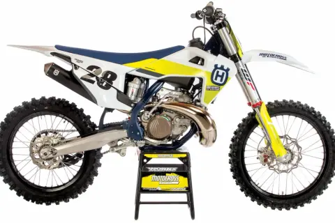 Motocykl Husqvarna 250 Enduro z numerem 28, biało-żółty, na czarnym stojaku.