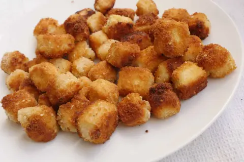 Krispiga, gyllene bitar av friterad tofu på en vit tallrik. Perfekt för ett snabbt och gott tofu recept.