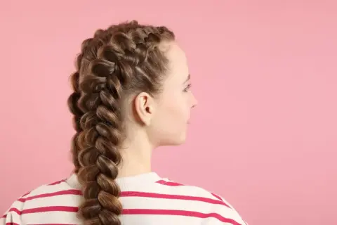 Una joven con dos trenzas gruesas y elaboradas, mostrando diferentes tipos de trenza.