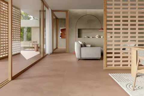Pavimento in gres porcellanato rosso per esterni, che crea un'atmosfera calda e accogliente in un soggiorno moderno con arredi minimalisti.