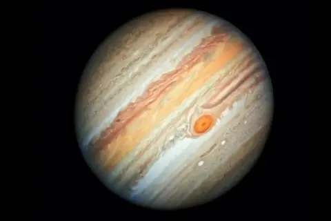 Jupiter, den femte planeten från solen, med sina virvlande molnband och den ikoniska Röda Fläcken.