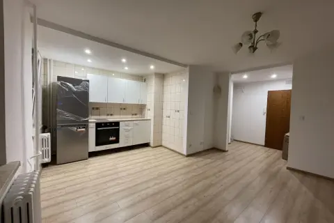 Jasne, nowoczesne mieszkanie do wynajęcia Nowy Sącz. Kuchnia z lodówką, piekarnikiem i szafkami. Jasne panele na podłodze.