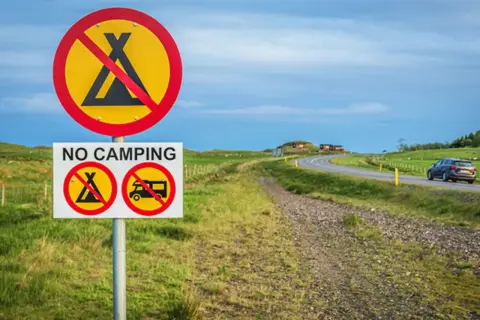 Schilder verbieten das Zelten und Wohnmobilfahren. Kein **island wildcampen** hier, nur eine Straße mit einem Auto.