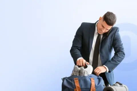 Biznesmen pakuje buty do torby sportowej, zastanawiając się, co ile godzin można korzystać z Multisport Plus.