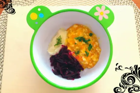 Pyszna potrawka z kurczaka dla niemowlaka z puree ziemniaczanym i buraczkami w miseczce w kształcie żabki.