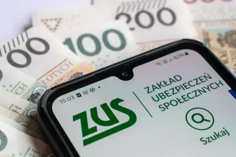 Telefon z aplikacją ZUS na tle polskich banknotów. Ubezpieczenie społeczne w zasięgu ręki.