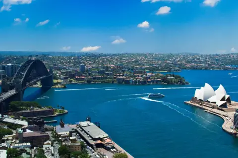 Widok na Zatokę Sydney z Operą i mostem Harbour Bridge. To właśnie Sydney, gdzie błękitna woda lśni w słońcu.
