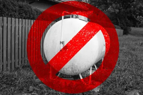 Zakaz ogrzewania gazowego z butli. Duży, biały zbiornik gazowy z czerwonym znakiem zakazu.