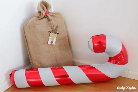 Un sac de Père Noël et un ballon de baudruche en forme de canne à sucre, symbolique de Noël.