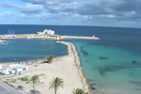 Piękna plaża i turkusowe morze w Tunezji. Październikowa pogoda idealna na spacer brzegiem.