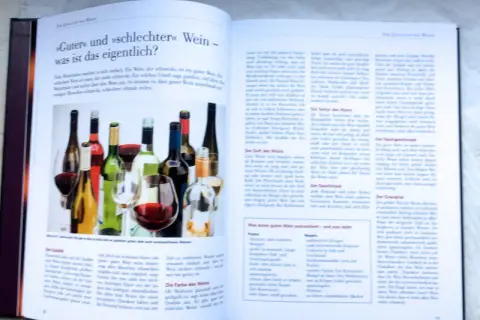 Flaschen mit Wein und Gläser, die eine Wein-Bewertung illustrieren.