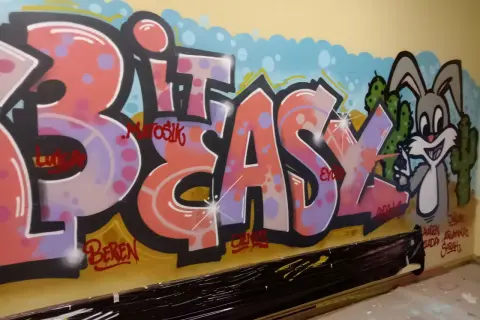 Buntes Graffiti mit Schriftzug "BIT EASY" und einem Hasen vor Kakteen.