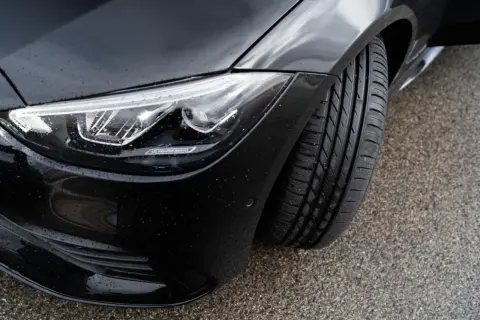Czarny samochód z nowymi oponami. Czy lepsze opony na przód czy tył? Woda na karoserii i reflektorze LED.