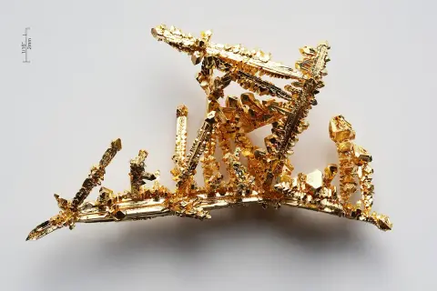 Złoto próba 525, krystaliczna struktura przypominająca miniaturowy, lśniący krajobraz.