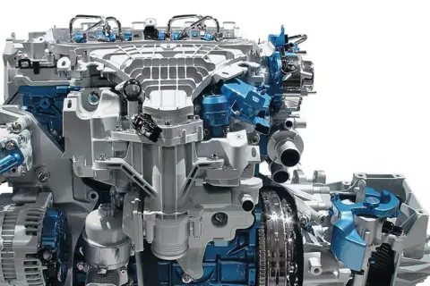 Silnik Ford Mondeo MK6, z widocznymi elementami układu paliwowego i alternatora, w kolorach białym i niebieskim.