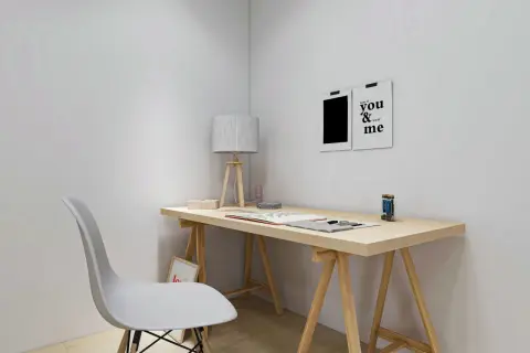 Un escritorio minimalista con tablero de madera, una silla blanca y dos cuadros decorativos. Ideal para hacer escritorio con tablero y crear un espacio de trabajo inspirador.