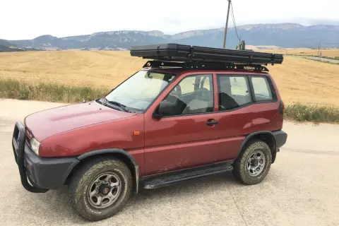 Nissan Terrano 2 corto con tienda de techo, listo para la aventura. Las medidas son ideales para explorar caminos rurales.