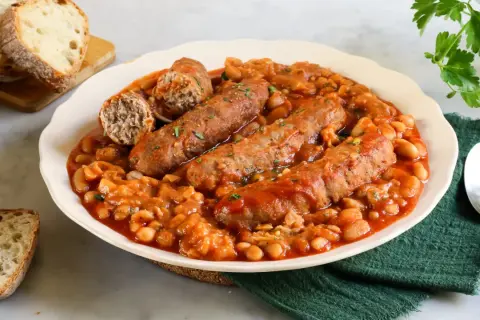 Salsiccia e fagioli in scatola ricetta: un piatto confortante con salsicce succulente e fagioli in salsa, accompagnato da pane croccante.
