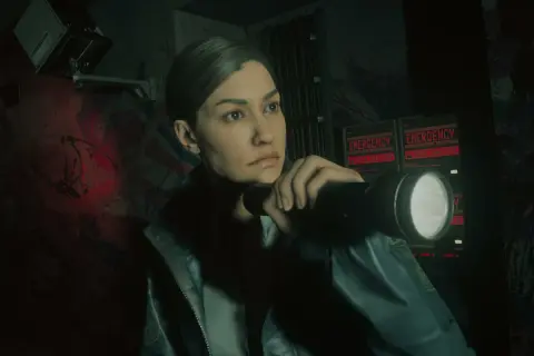 Saga Alan Wake 2 DLC: Agentka z latarką bada mroczne korytarze, gdzie migają czerwone napisy "EMERGENCY - SEEK SHELTER".