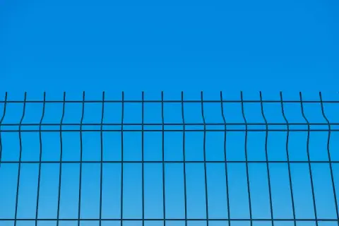 Siatka ogrodzeniowa na tle błękitnego nieba. Dowiedz się, jak wyznaczyć poziom sznurkiem, by uzyskać idealnie proste linie.