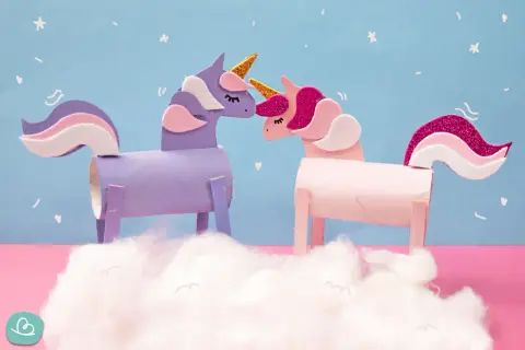 Zwei selbstgebastelte Einhörner aus Klopapierrollen, ein lila und ein rosa, stehen sich gegenüber. Ein tolles Bastelprojekt für Kinder!