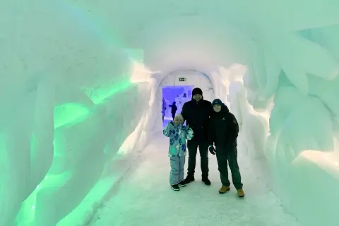 Rodzina w lodowym tunelu, gdzieś w okolicy wioski świętego mikołaja. Napis "Welcome to the..." wyryty w lodzie.
