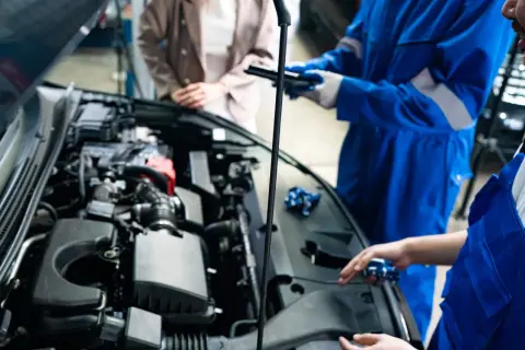 Mekanikerna diskuterar hur ofta ska man serva bilen medan motorhuven är öppen.