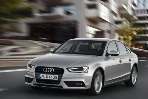 Srebrne Audi A4 B8 w ruchu miejskim. Typowe usterki tego modelu mogą dotyczyć elektroniki lub układu napędowego, ale ten egzemplarz wygląda bez zarzutu.