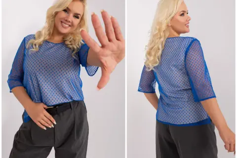 Uśmiechnięta kobieta w niebieskiej, ażurowej bluzce damskiej plus size w kropki, z rękami w geście "stop".