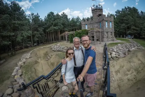 Rodzina pozuje do selfie przed kamiennym zamkiem, odkrywając nietypowe atrakcje Podlasia.