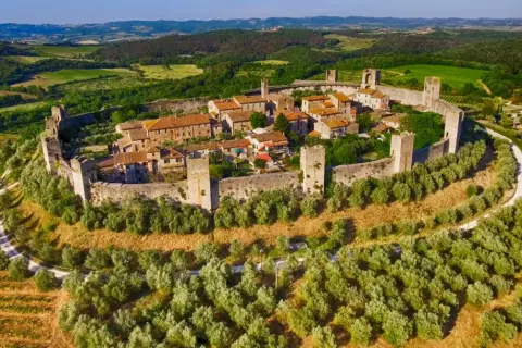 Borgo medievale fortificato in Toscana, circondato da uliveti e colline verdi. Un gioiello tra i borghi da visitare in Toscana.