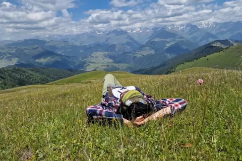 Odpoczynek na łące w Tuszetii, Gruzja. W tle majestatyczne góry Kaukazu.