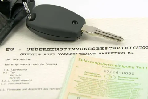 Clé de voiture sur un certificat de conformité européen. Ce document atteste de la conformité d'un véhicule, essentiel pour l'immatriculation, y compris pour les poids lourds.