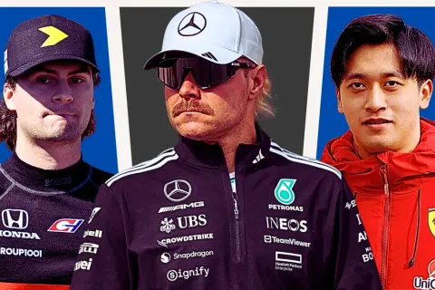 Trzech kierowców formuły 1: z lewej kierowca w czarnej bluzie z żółtym symbolem, w środku kierowca Mercedesa w białej czapce i okularach, z prawej kierowca Ferrari w czerwonej kurtce.