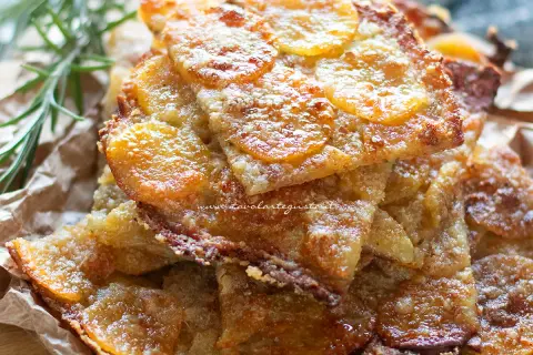Schiacciata di patate croccante, dorata e invitante, con fette sottili di patate e un tocco di rosmarino.