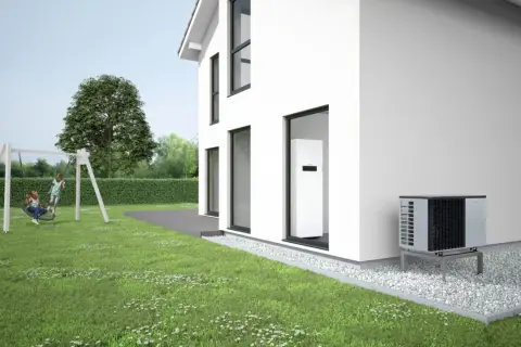 Casa moderna con jardín y columpio. Se ven bombas de calor para pisos, una unidad exterior y otra interior, garantizando confort y eficiencia.