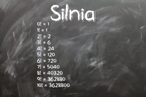 Na tablicy napisano "Silnia" i przykłady obliczeń: 0!=1, 1!=1, 2!=2, 3!=6, 4!=24, 5!=120, 6!=720, 7!=5040, 8!=40320, 9!=362880, 10!=3628800.
