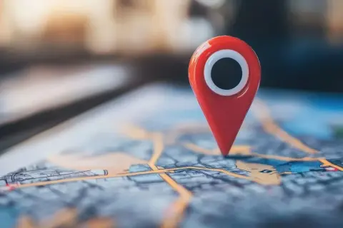 Czerwony pin na mapie cyfrowej symbolizuje punkt na trasie, przypominając o historii lokalizacji Google.