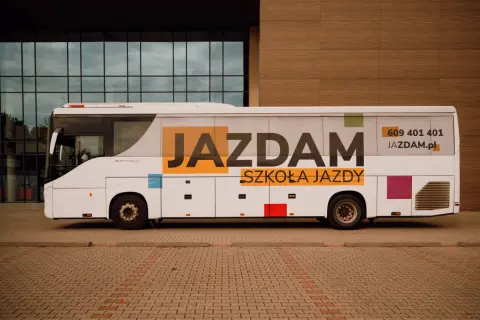 Biały autokar z napisem "JAZDAM SZKOŁA JAZDY" i numerem telefonu. Idealny do nauki jazdy kategorii D.