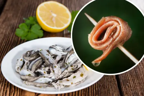 Rolowana ryba anchois na wykałaczce i talerz z marynowanymi rybkami, cytryną i natką pietruszki.