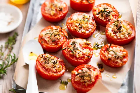 Tomates provençales garnies d'herbes et de fromage, rôties sur une plaque. Un délice parfumé !