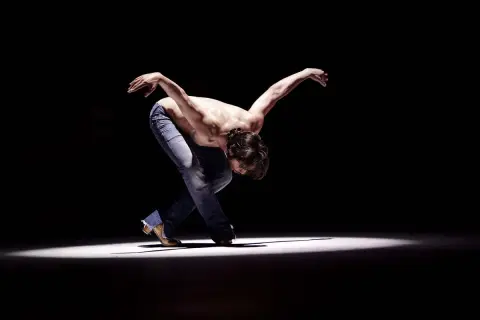 Joaquín Cortés flamenco, un torbellino de pasión y arte, se mueve con fuerza en el escenario.
