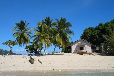 Piękna plaża z palmami i domkiem, idealne miejsce na wakacje. Zastanawiasz się, ile się leci na Madagaskar?