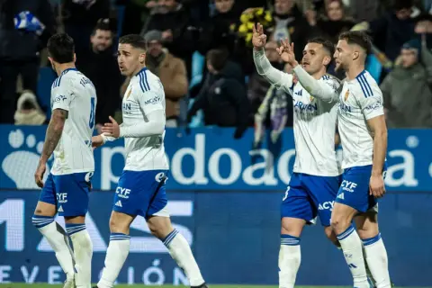 Jugadores de fútbol del Zaragoza celebran en el campo.