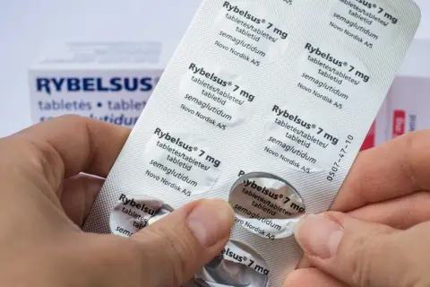 Dłonie trzymają opakowanie leku Rybelsus 7 mg, zawierającego tabletki z semaglutydem.