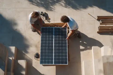 Dos hombres instalan paneles solares. ¿Cuántas placas solares necesito para 3000w?
