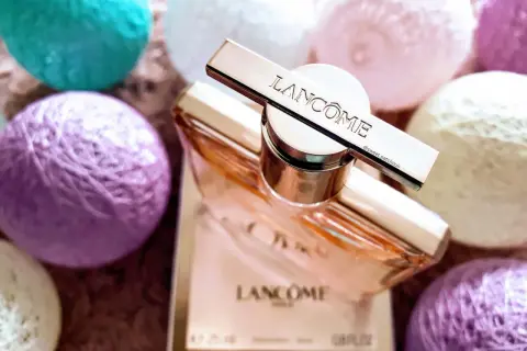 Elegancki flakon Lancome Idole 100ml otoczony pastelowymi kulkami.